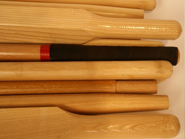 Custom wood handles designed for various applications, including wheelbarrow handles, snow shovel handles, and wood stick ball bats.